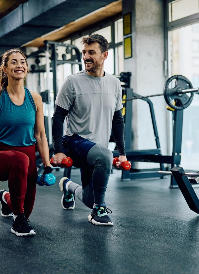 man and woman lifting weights in a gym