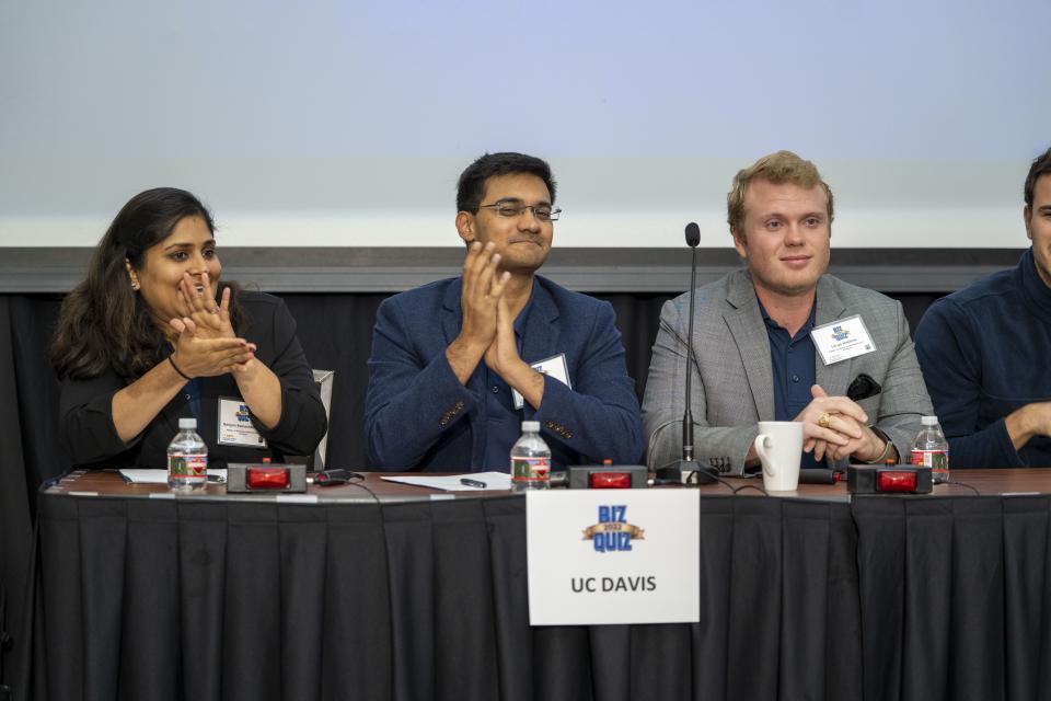 Three competitors on stage clapping