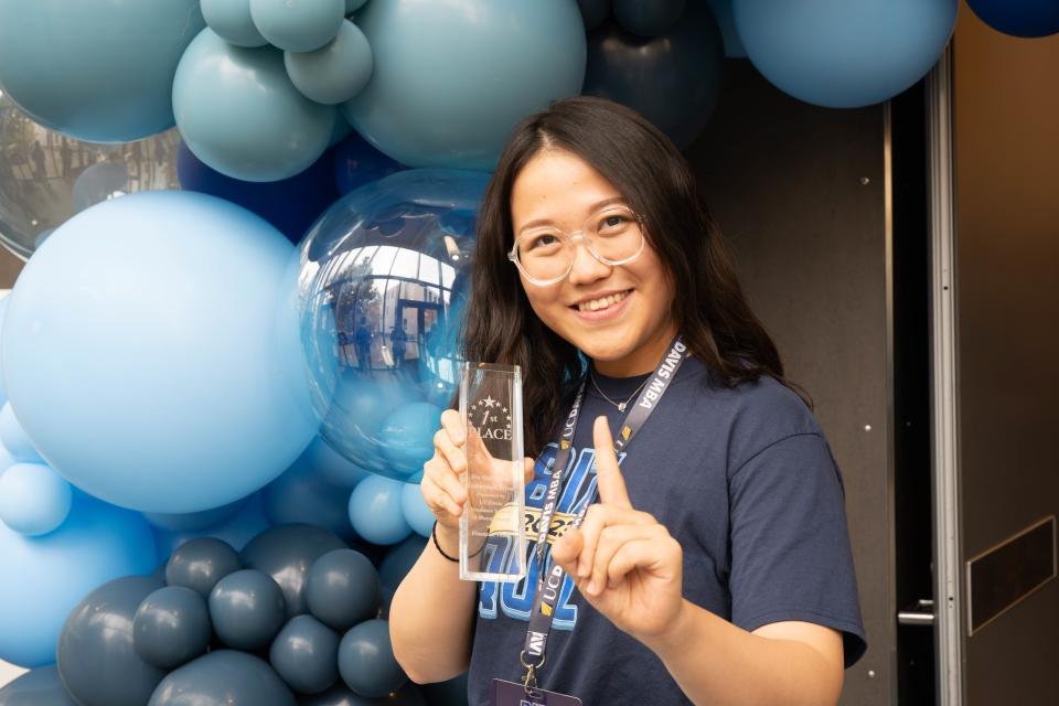 Min Zuh holding up a trophy 