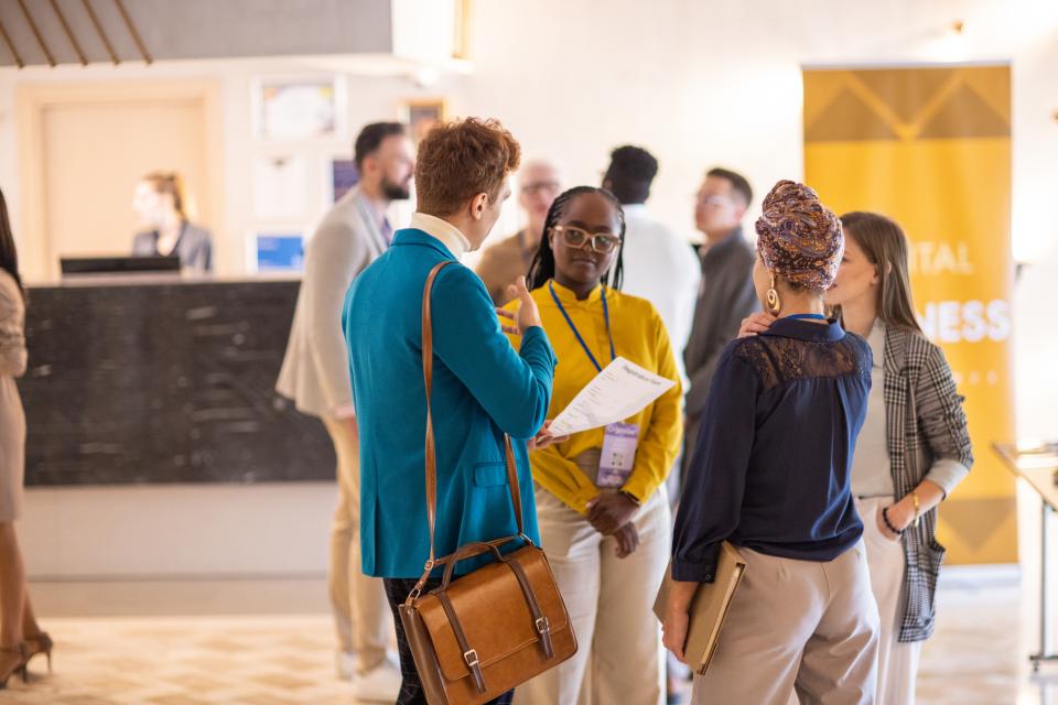 A group of business people casually talking in the lobby of a hotel before a business conference event starts