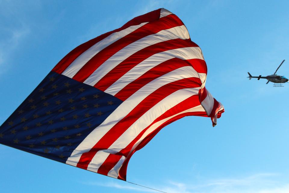 American flag with helicopter in background