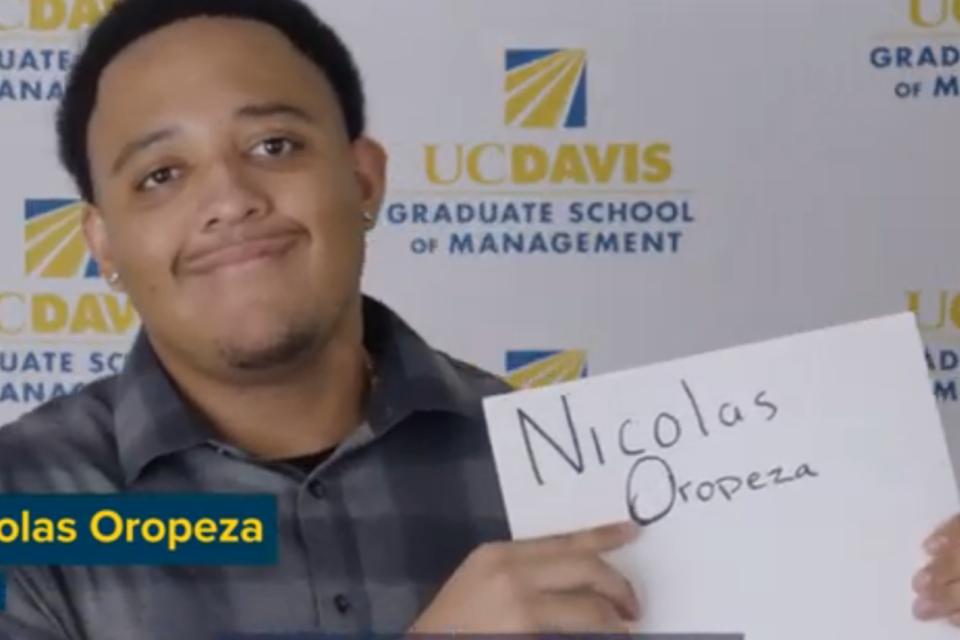 Nicolas holding up a sign with his name