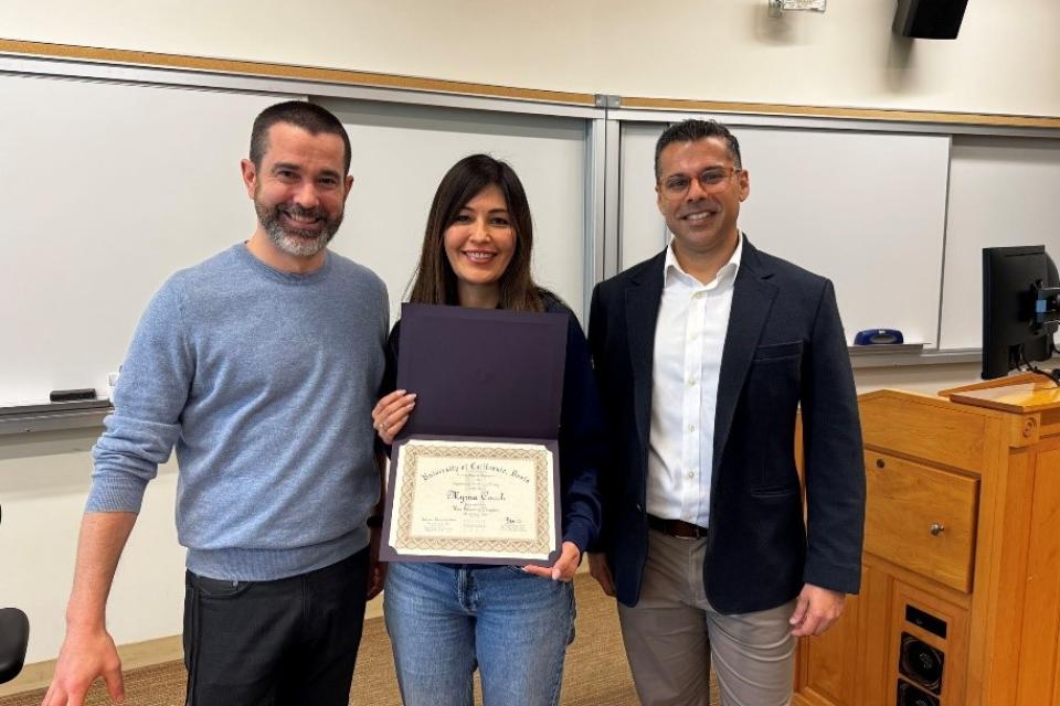 Myrna Robles Couch holding up a certificate with Ben Montpetit and Ashwin Aravindakshan